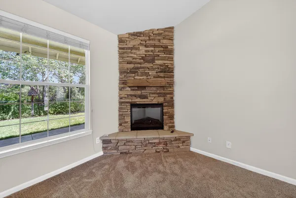 a living room with a fireplace and a floor to ceiling window