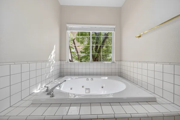 a white bath tub sitting in a bathroom next to a window