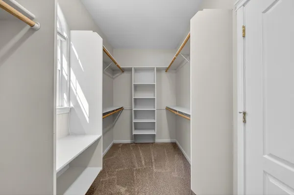 a view of walk in closet with empty racks