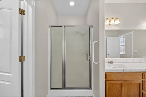 a bathroom with a shower sink and mirror