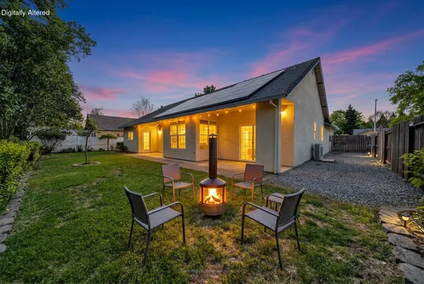 a backyard of a house with table and chairs
