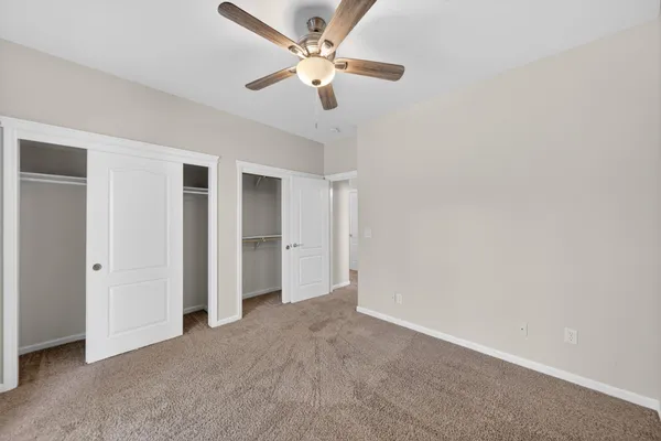 a view of an empty room with a ceiling fan