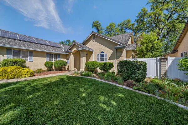 a front view of a house with a garden and plants