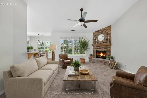 a living room with furniture a fireplace and a large window