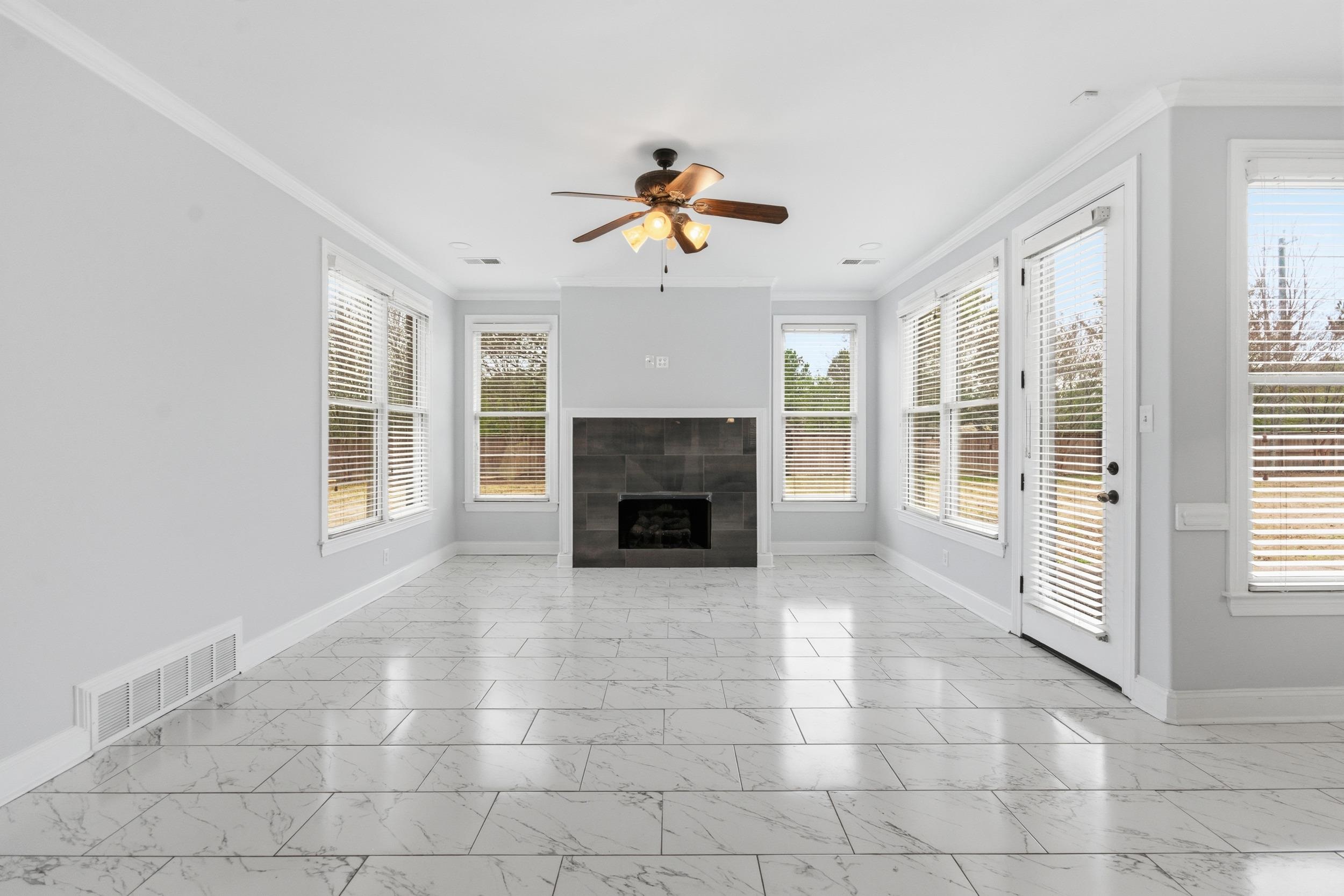 11080 Shelby Post Road Collierville, TN 38017 - Photo 7 of 39 Unfurnished living room featuring ornamental molding, a fireplace, light marble finish flooring, and a ceiling fan