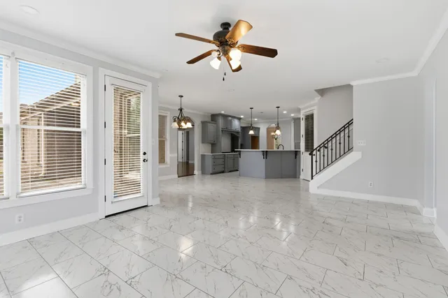 a view of an empty room with a ceiling fan and window