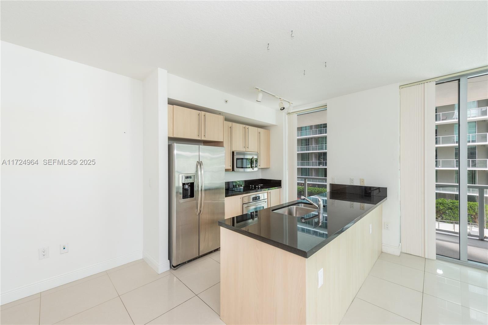 79 Southwest 12th Street, Unit 1107S Miami, FL 33130 - Photo 4 of 26 a kitchen with stainless steel appliances granite countertop a sink and a refrigerator