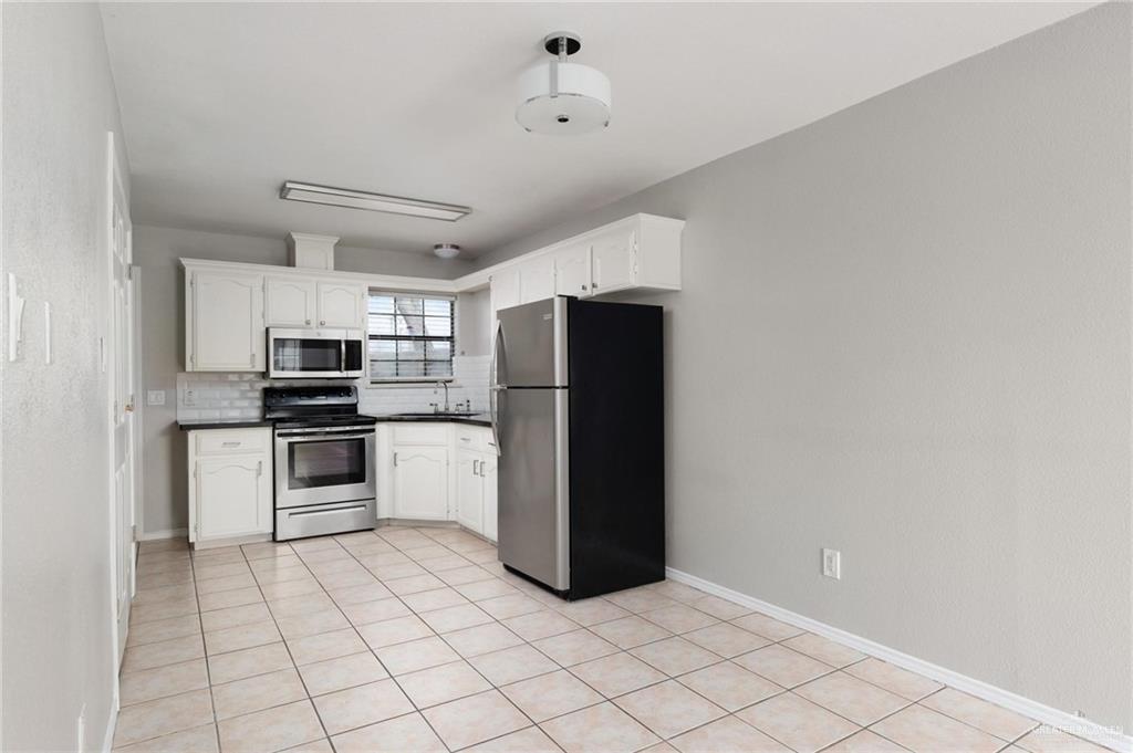 3505 Amando Street, Unit 3 Edinburg, TX 78539 - Photo 4 of 17 a kitchen with granite countertop a refrigerator and a stove top oven