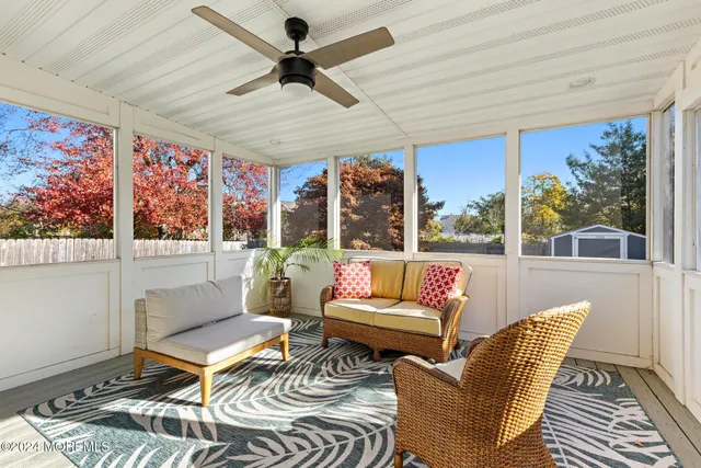 a living room with patio furniture and a floor to ceiling window
