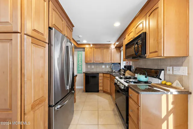 a kitchen with stainless steel appliances granite countertop a refrigerator a stove and a sink
