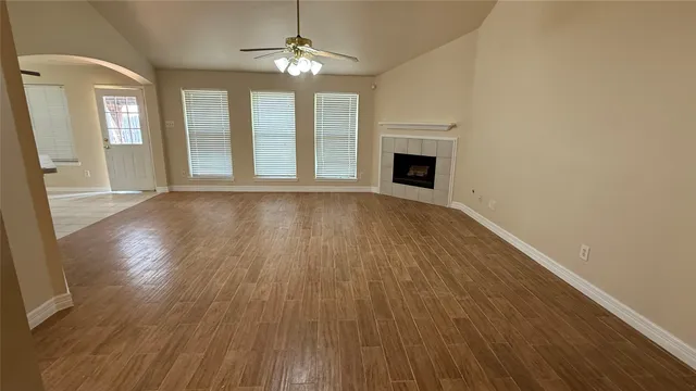 a view of a room with wooden floor and a ceiling fan