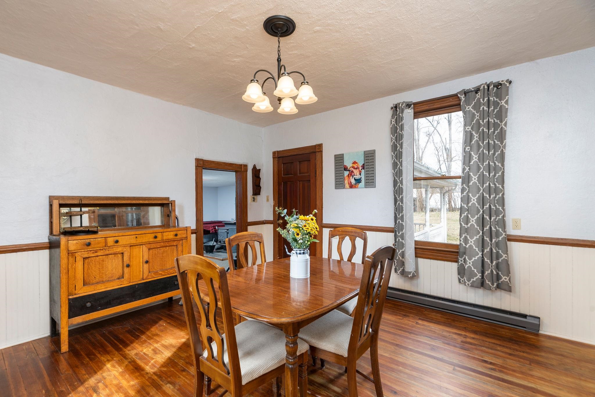 503 Augusta Avenue Grottoes, VA 24441 - Photo 17 of 61 a dining room with wooden floor a chandelier a wooden table and chairs