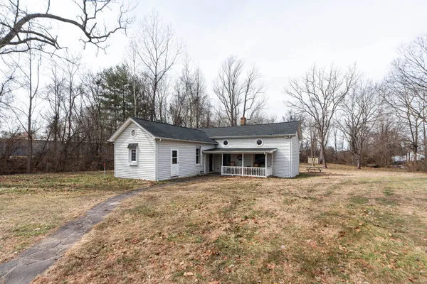 a white house that has a tree in front of it