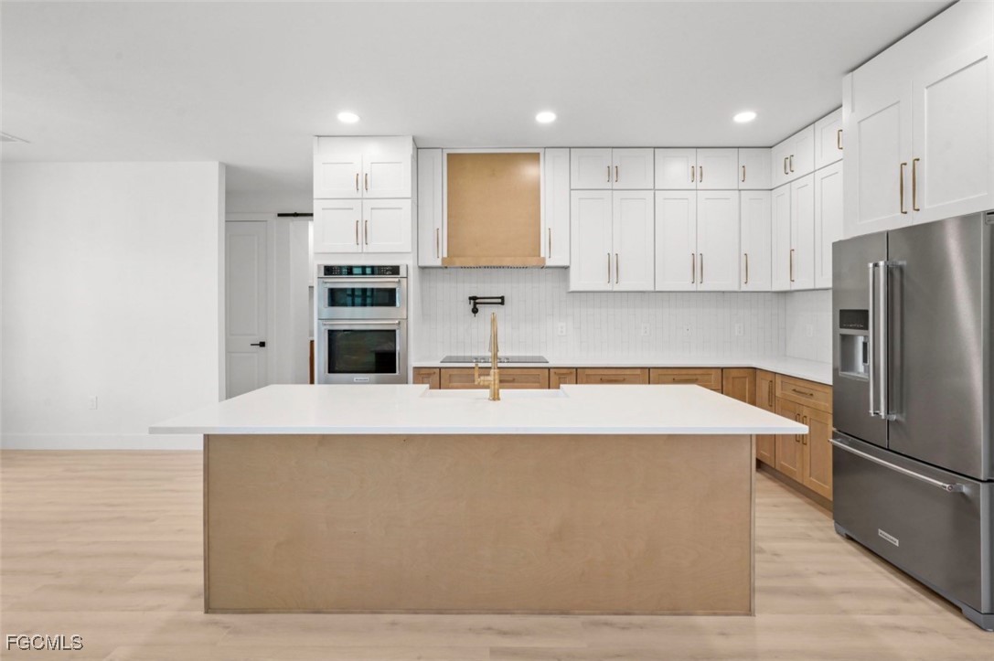 2310 Columbus Avenue Alva, FL 33920 - Photo 14 of 43 a large kitchen with stainless steel appliances a large counter top a stove and a refrigerator