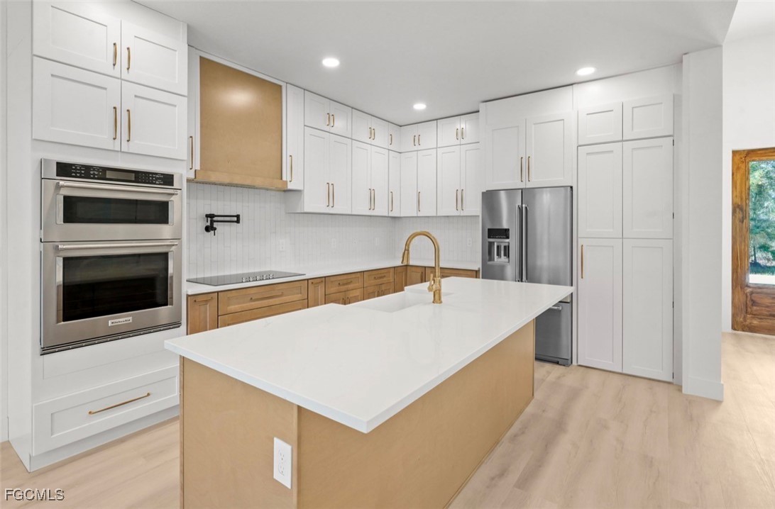 2310 Columbus Avenue Alva, FL 33920 - Photo 17 of 43 a kitchen with stainless steel appliances a refrigerator sink and cabinets