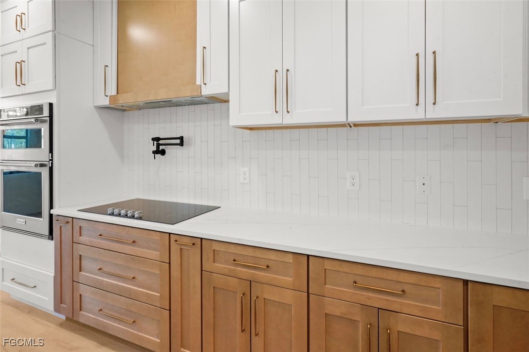 2310 Columbus Avenue Alva, FL 33920 - Photo 21 of 43 a kitchen with white cabinets and a stove