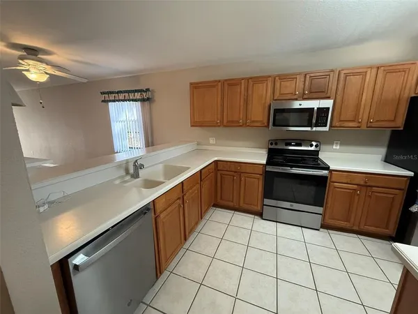a kitchen with a sink a stove top oven a counter space and cabinets