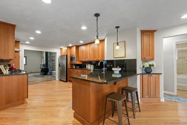 a large kitchen with stainless steel appliances granite countertop a stove a sink dishwasher and a refrigerator
