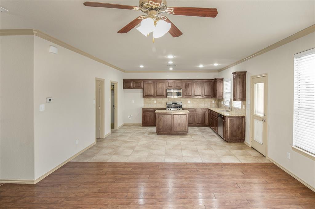 10033 Butte Meadows Drive Fort Worth, TX 76177 - Photo 12 of 31 a view of a kitchen with a stove cabinets and wooden floor