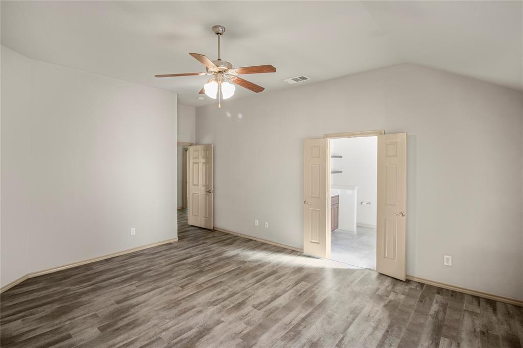 10033 Butte Meadows Drive Fort Worth, TX 76177 - Photo 24 of 31 an empty room with wooden floor fan and windows