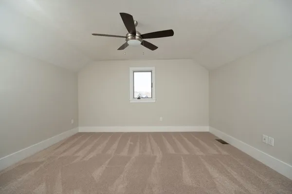an empty room with a window and a ceiling fan