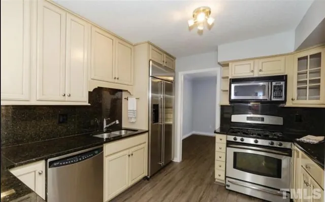 a kitchen with stainless steel appliances a stove a sink and a microwave