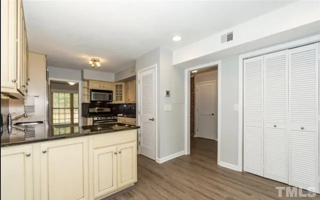 a kitchen with stainless steel appliances granite countertop a stove a sink and a refrigerator