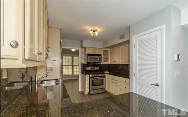 a kitchen with stainless steel appliances granite countertop a stove a sink and a refrigerator