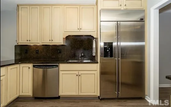 a kitchen with stainless steel appliances granite countertop a refrigerator a stove and a microwave