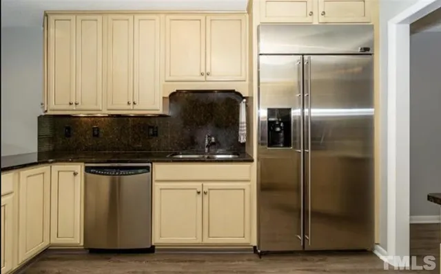 a kitchen with stainless steel appliances granite countertop a refrigerator a stove and a microwave