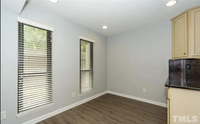 an empty room with wooden floor and a window