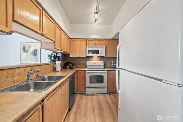a kitchen that has a sink cabinets counter space and stainless steel appliances