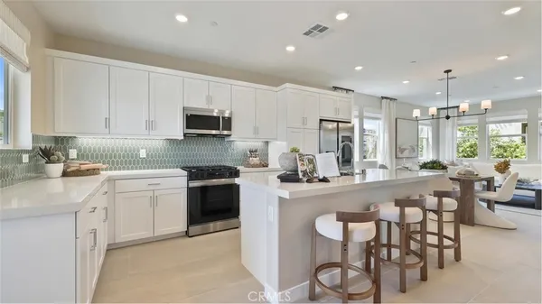 a kitchen with a sink and chairs