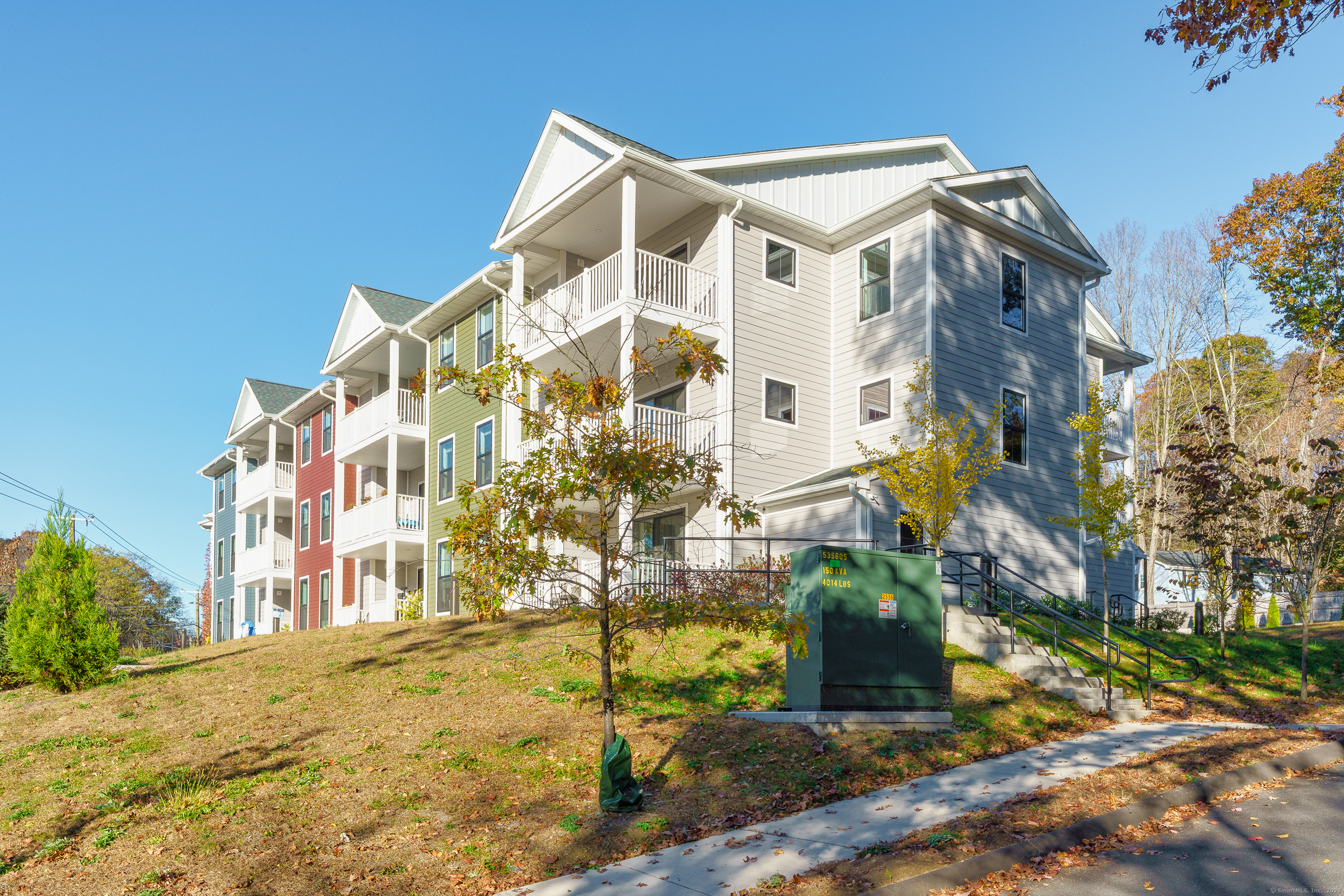 a view of a white building next to a yard