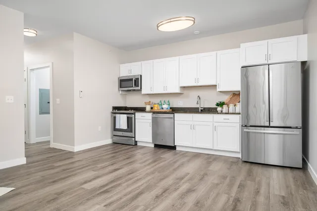 a kitchen with white cabinets and stainless steel appliances