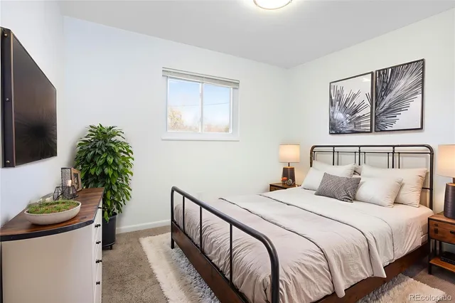 a bedroom with a bed and a potted plant
