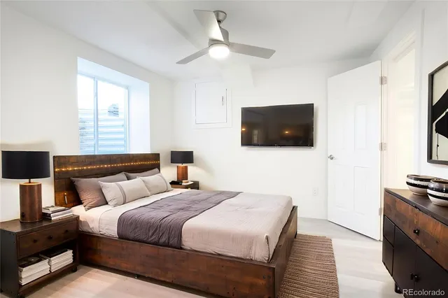 a bedroom with bed tv and a window