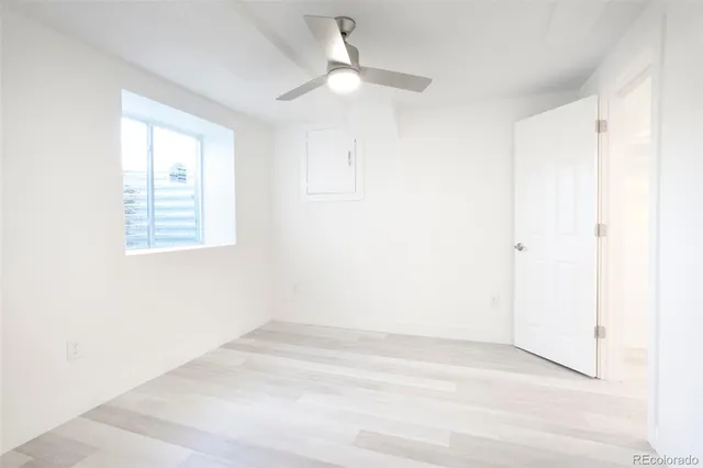 an empty room with a window and a fan