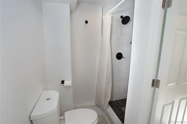a bathroom with a toilet and a shower