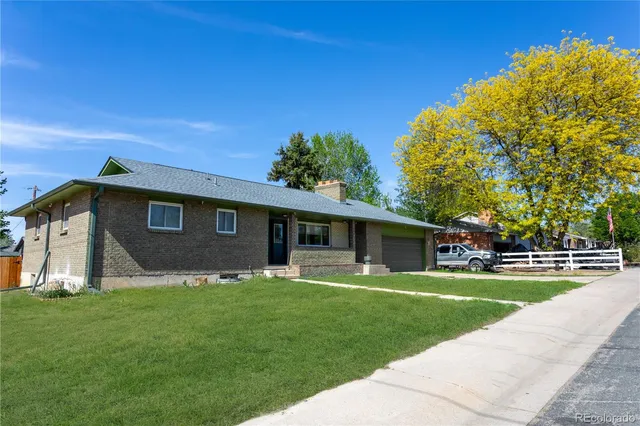 a front view of a house with a yard and trees