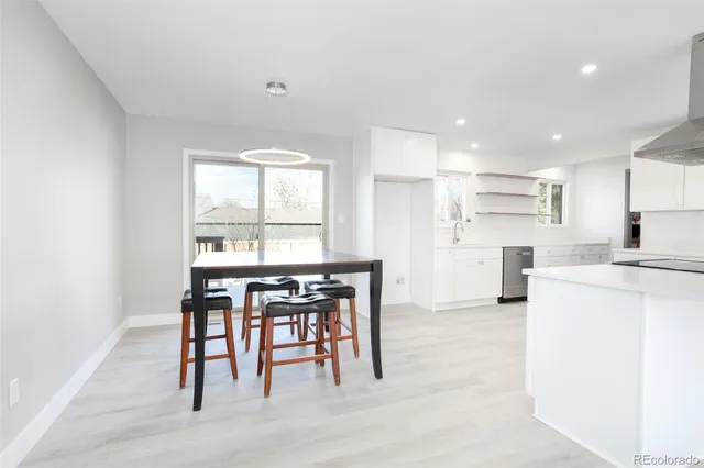 a kitchen with stainless steel appliances kitchen island granite countertop a table and chairs in it