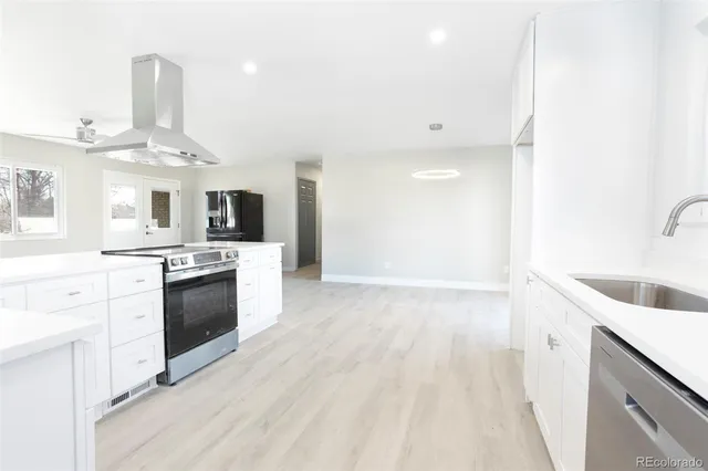 a kitchen with granite countertop a sink cabinets stainless steel appliances and a counter top space