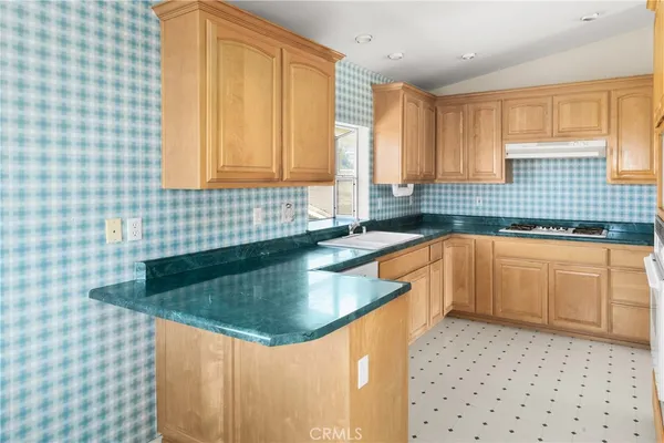 a kitchen with a sink a stove a window and cabinets
