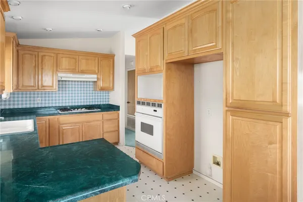 a kitchen with granite countertop a refrigerator and a sink