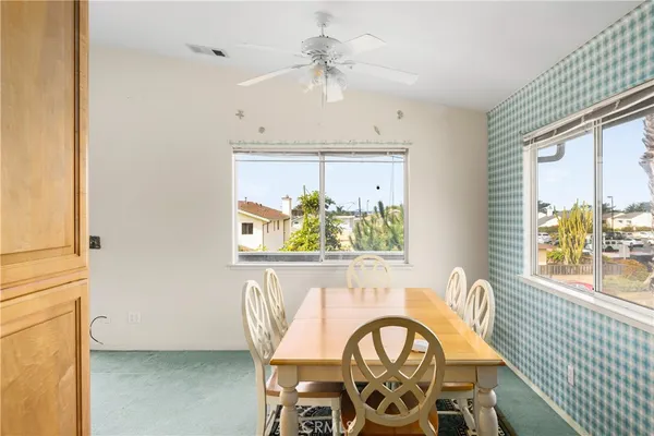 a view of a dining room with furniture a chandelier and a window