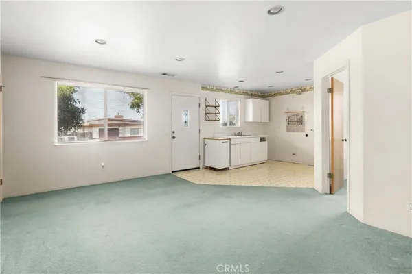a view of a kitchen with refrigerator and windows