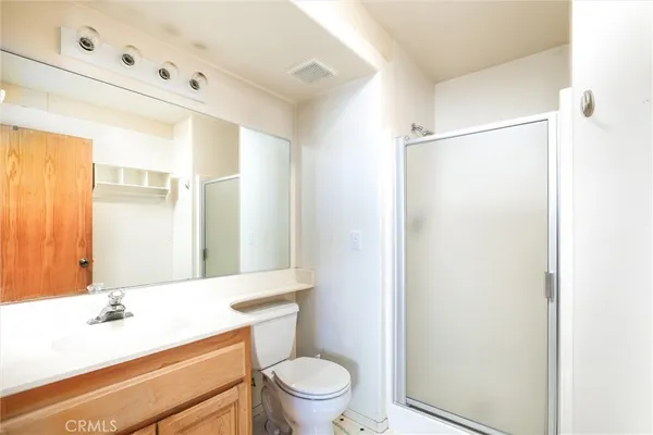 a bathroom with a sink a toilet a mirror and shower