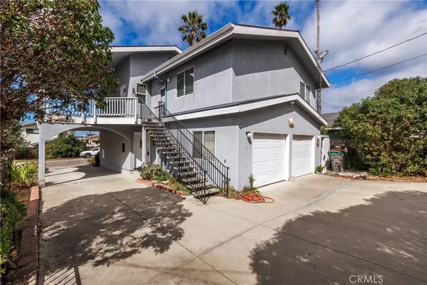 a view of house with wooden stairs and potted plants