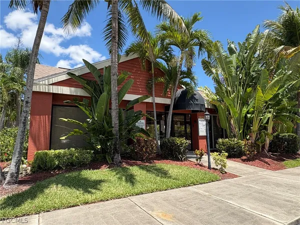 a view of a house with a yard and potted plants