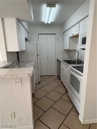 a kitchen with a stove a sink and a refrigerator